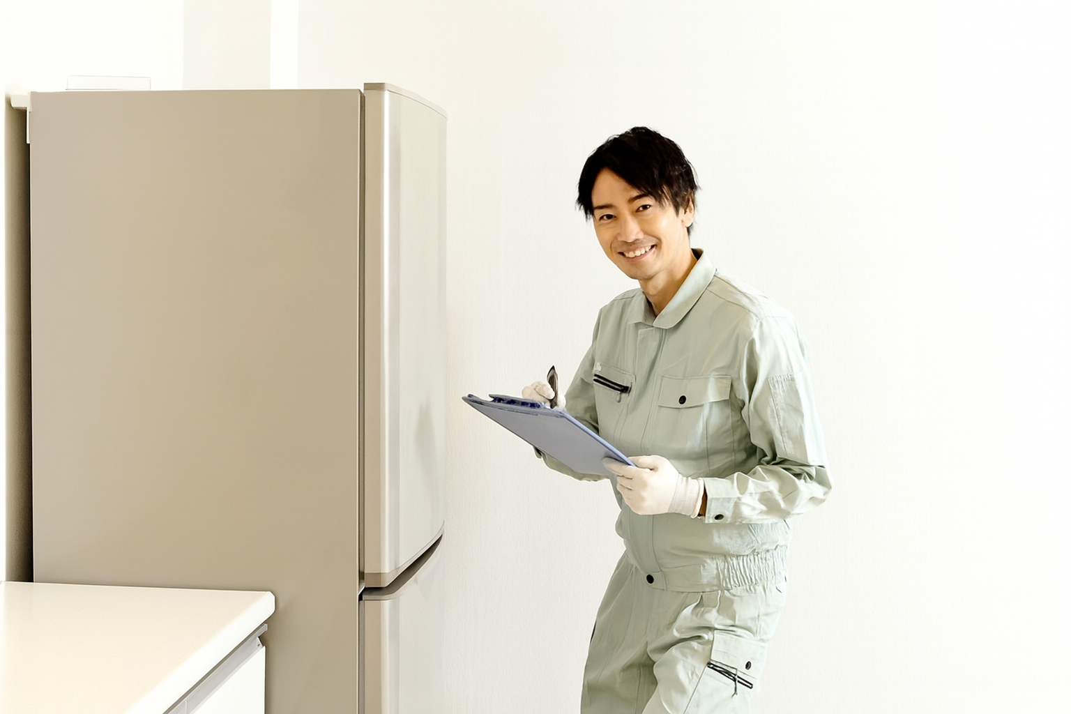 高知市で家電の出張買取を行う様子。リサイクルショップのスタッフが冷蔵庫を査定しているシーン。